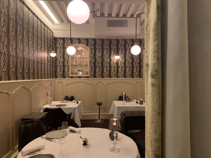 ラ・メール・ブラジエの店内。白いクロスを掛けたテーブルと黒い椅子が並んでいます。