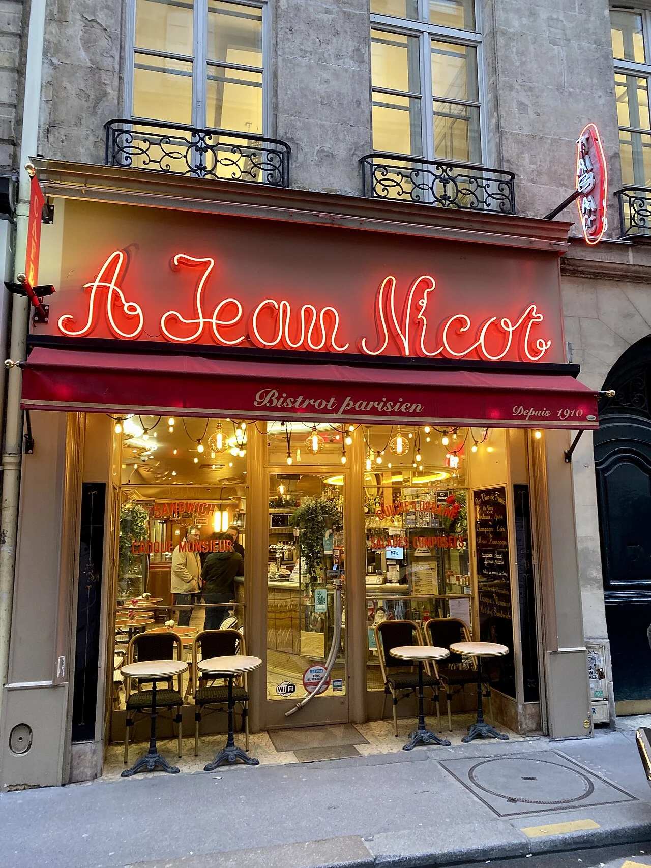 Insegna rossa e sala del bistrot À Jean Nicot